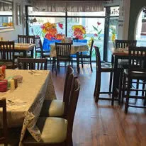Inside Riverside Cafe dining area with tables, chairs, and window murals