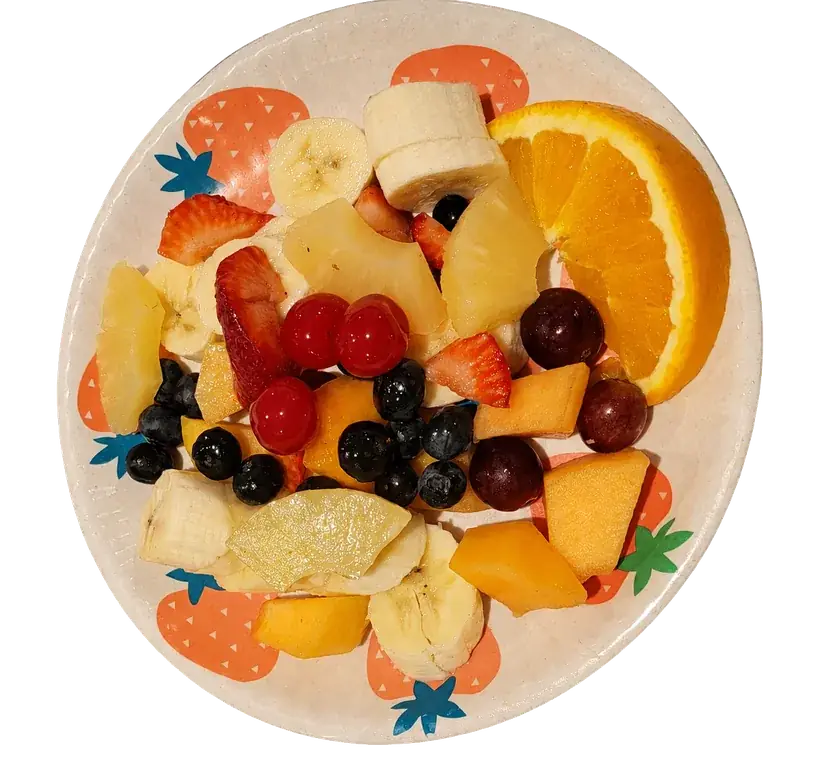 Fresh fruit plate with orange, berries, pineapple, grapes, banana, and melon